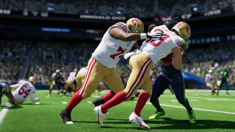 madden 24 three players tackle for ball in stadium with others playing in blurry background