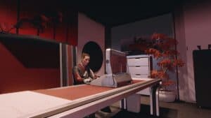 starfield woman sits at desk in red and white office with computer tree and cabinet in corner