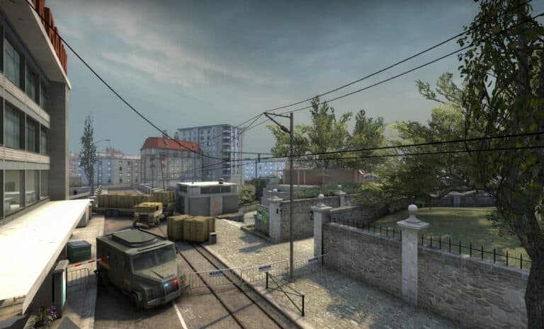 cs2 map view during cloudy day with trees trucks on cobblestone streets and gates